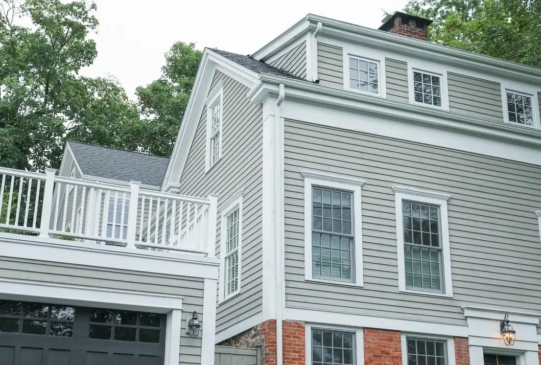 Gray lap siding with white trim on a two-story colonial home with a balcony